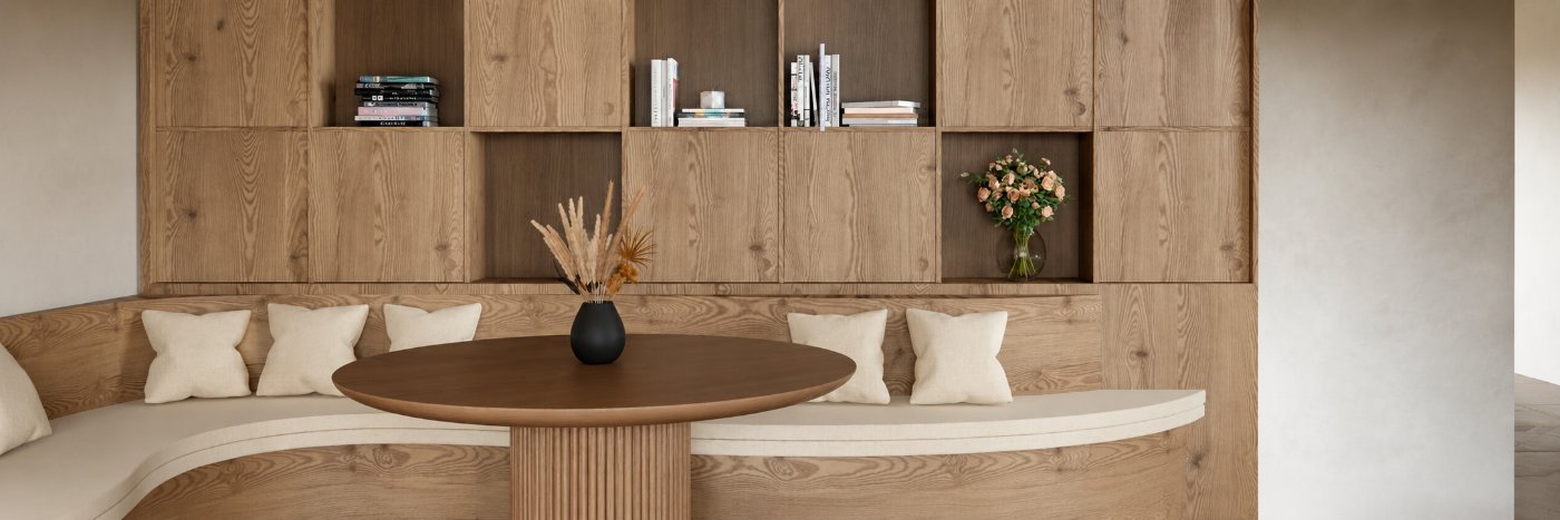 Curved oak banquette nook with round pedestal table and shelving